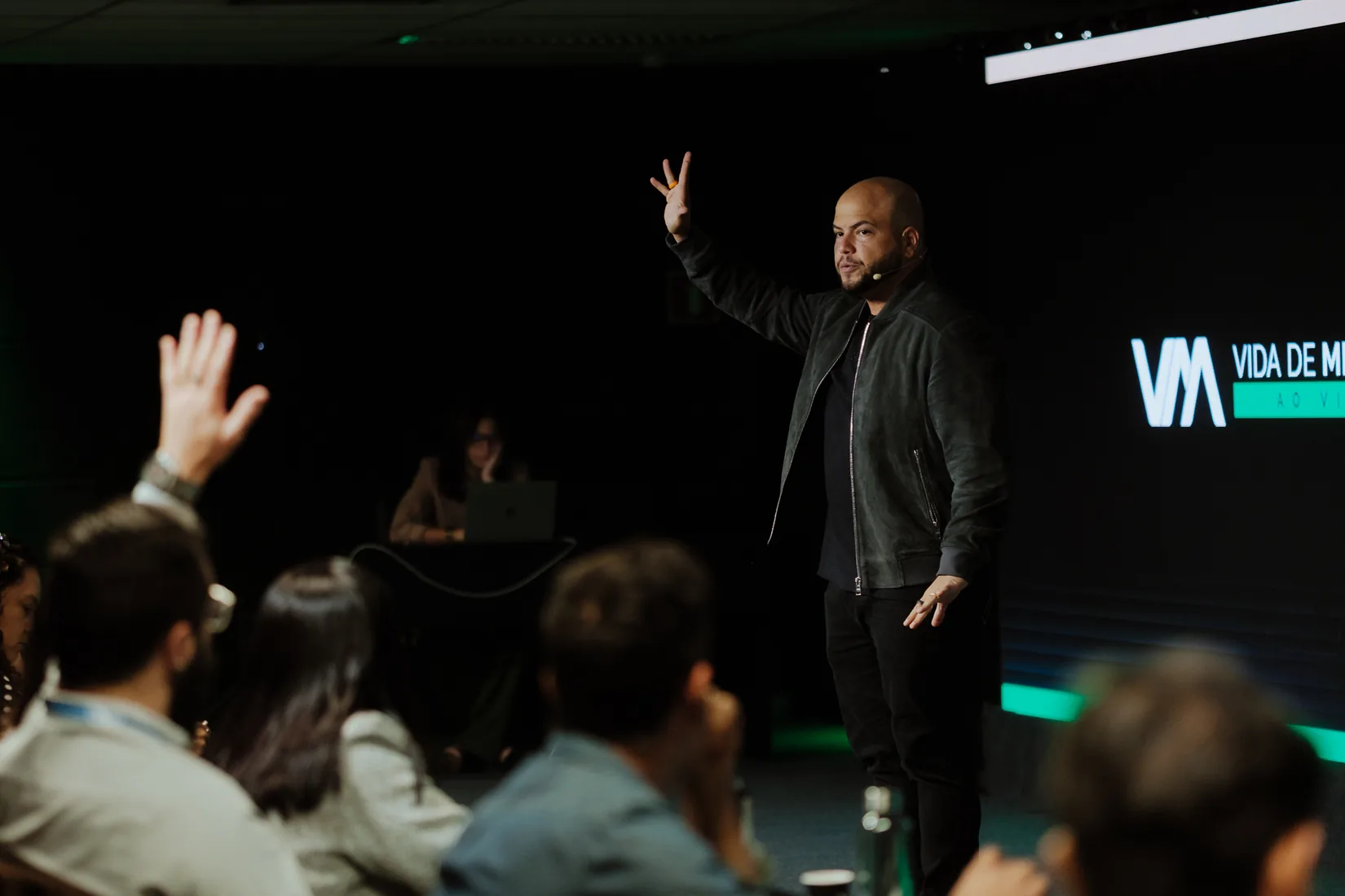 Victor Damásio no palco, de braço erguido, com a marca Vida de Mentor ao fundo